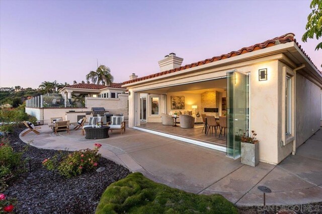 back house at dusk with a patio