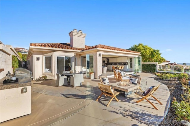 back of house featuring a patio and an outdoor kitchen