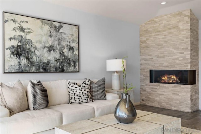 living room featuring hardwood / wood-style flooring, lofted ceiling, and a fireplace