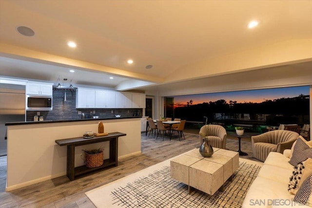 interior space featuring lofted ceiling and light wood-type flooring