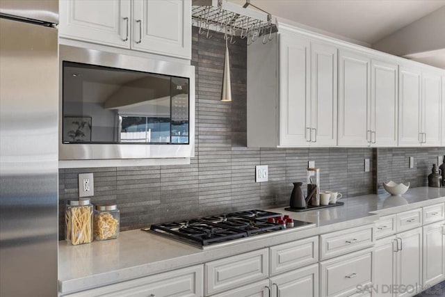 kitchen featuring decorative backsplash, stainless steel appliances, and white cabinetry