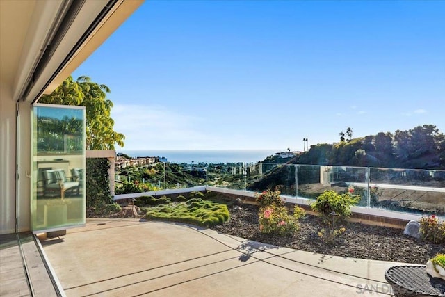 view of patio featuring a water view and a balcony