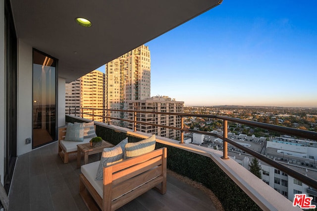 balcony at dusk featuring an outdoor hangout area