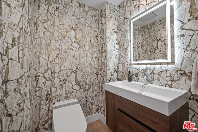 bathroom featuring hardwood / wood-style flooring, vanity, and toilet