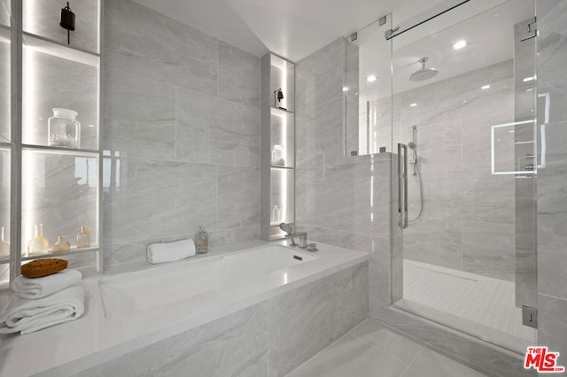 bathroom featuring tile walls and independent shower and bath