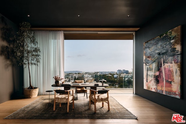 dining room featuring a wall of windows and light wood-type flooring