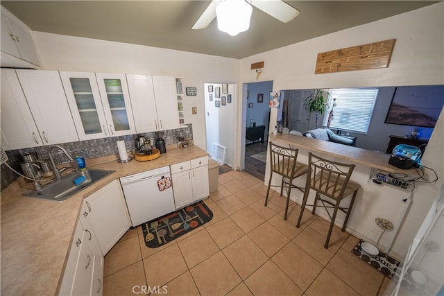 kitchen with decorative backsplash, dishwasher, white cabinets, and sink