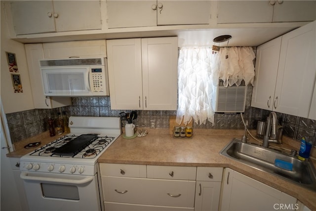 kitchen featuring white appliances, tasteful backsplash, white cabinetry, and sink