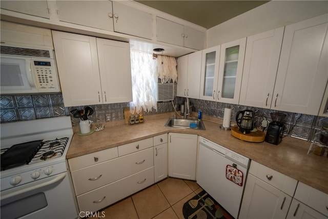 kitchen featuring light tile patterned flooring, white appliances, white cabinetry, and sink