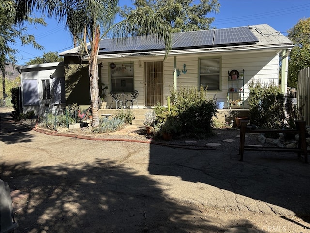 view of front of property with solar panels and covered porch