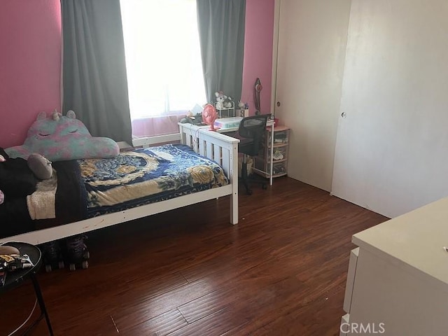 bedroom with dark hardwood / wood-style flooring