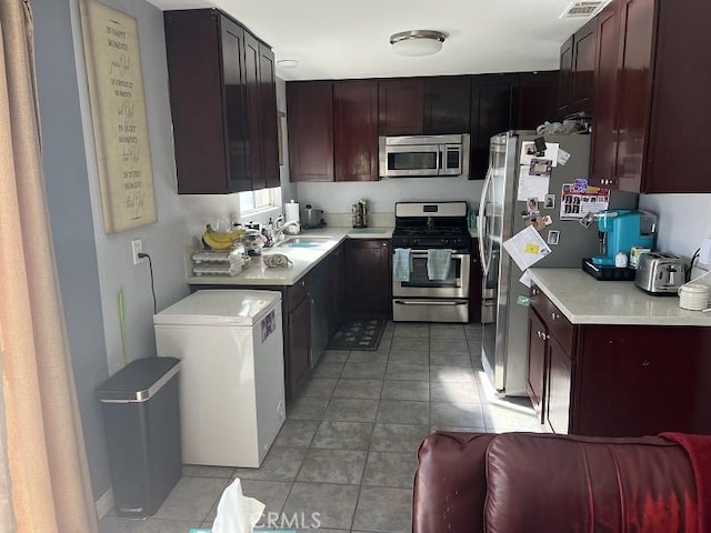 kitchen with sink, light tile patterned floors, and stainless steel appliances