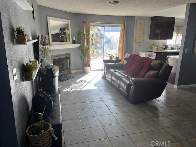 living room featuring light tile patterned flooring and a textured ceiling