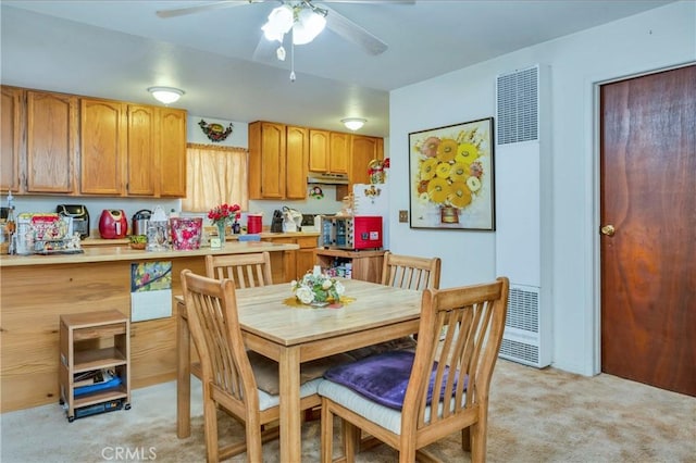 carpeted dining room featuring ceiling fan