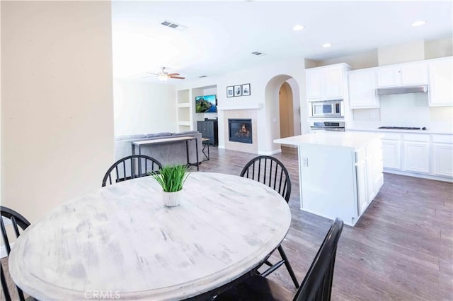 dining area with dark hardwood / wood-style flooring, built in features, and ceiling fan