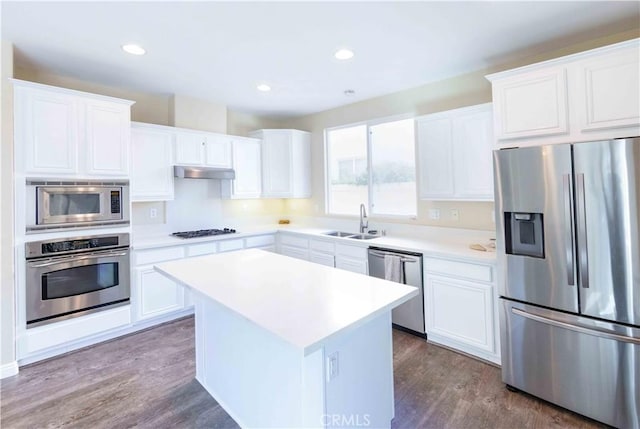 kitchen featuring appliances with stainless steel finishes, sink, a center island, dark hardwood / wood-style floors, and white cabinetry