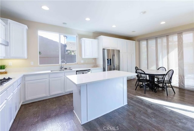 kitchen with stainless steel appliances, white cabinetry, dark wood-type flooring, and sink