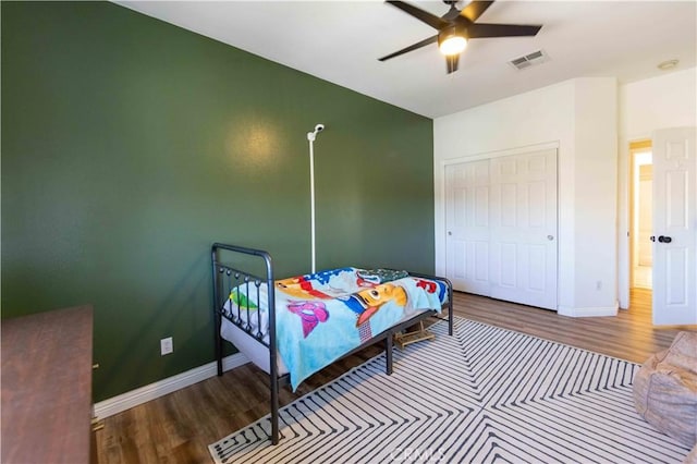 bedroom with hardwood / wood-style flooring, ceiling fan, and a closet