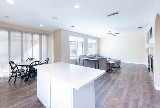 kitchen with dark hardwood / wood-style flooring, white cabinetry, ceiling fan, and a kitchen island