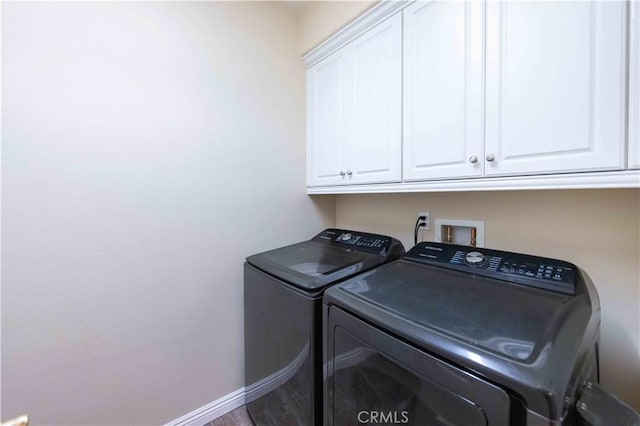 laundry area featuring cabinets, independent washer and dryer, and wood-type flooring