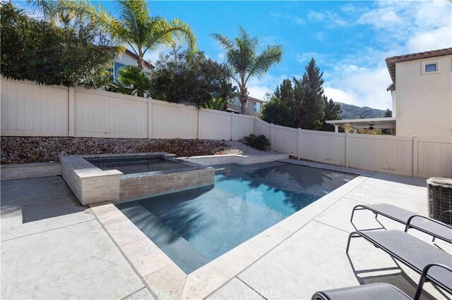 view of swimming pool with an in ground hot tub, a mountain view, and central AC unit