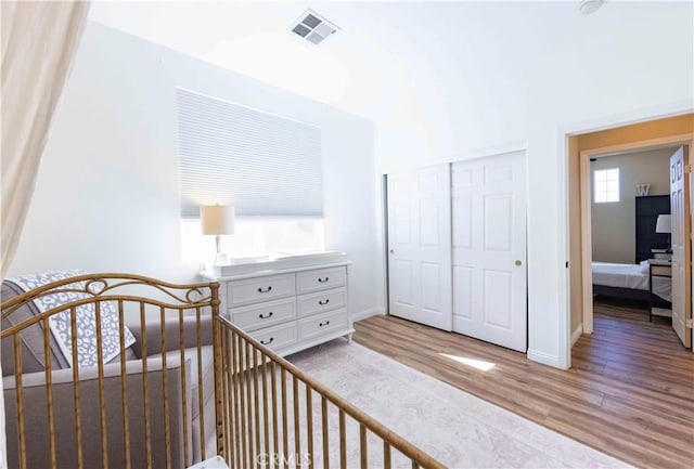 bedroom featuring a nursery area, a closet, and light hardwood / wood-style floors