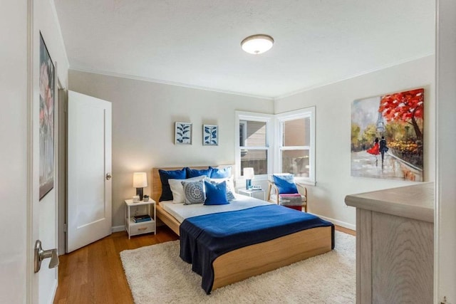 bedroom with hardwood / wood-style floors and ornamental molding