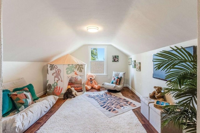 playroom featuring dark wood-type flooring and vaulted ceiling