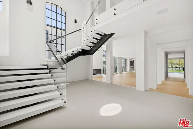 staircase featuring hardwood / wood-style floors and a high ceiling