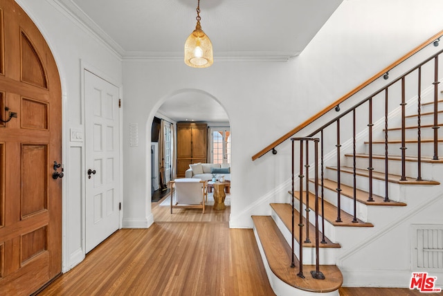 foyer featuring hardwood / wood-style floors and crown molding