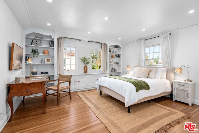 bedroom with multiple windows and light hardwood / wood-style floors