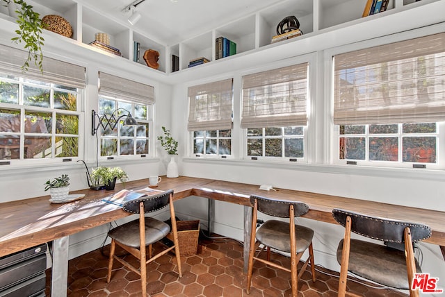 sunroom with breakfast area and rail lighting