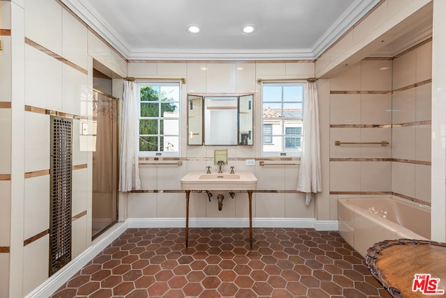 bathroom featuring independent shower and bath, a wealth of natural light, ornamental molding, and sink