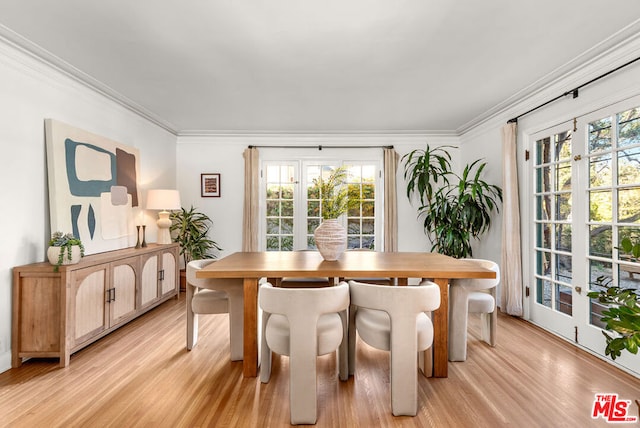 dining room with crown molding, french doors, plenty of natural light, and light wood-type flooring