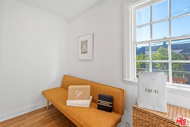 sitting room with hardwood / wood-style flooring, plenty of natural light, and ornamental molding