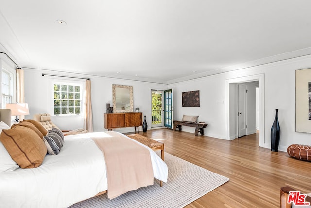 bedroom featuring multiple windows, crown molding, and hardwood / wood-style flooring