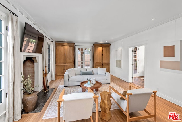 living room with light wood-type flooring and ornamental molding