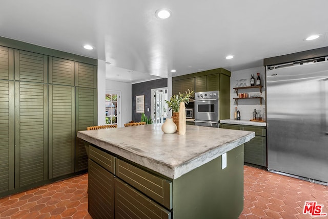 kitchen featuring a center island, appliances with stainless steel finishes, and green cabinetry