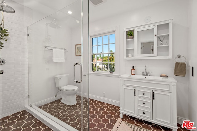 bathroom featuring tile patterned flooring, vanity, toilet, and an enclosed shower