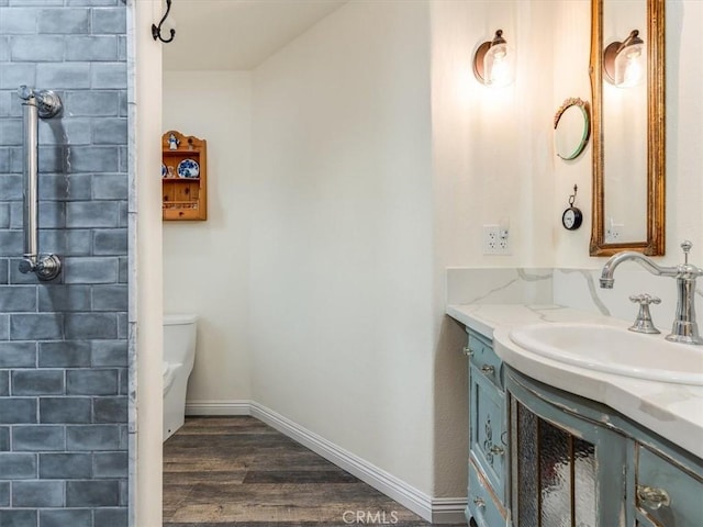 bathroom featuring toilet, vanity, and hardwood / wood-style flooring