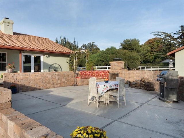 view of patio / terrace with a fireplace and area for grilling