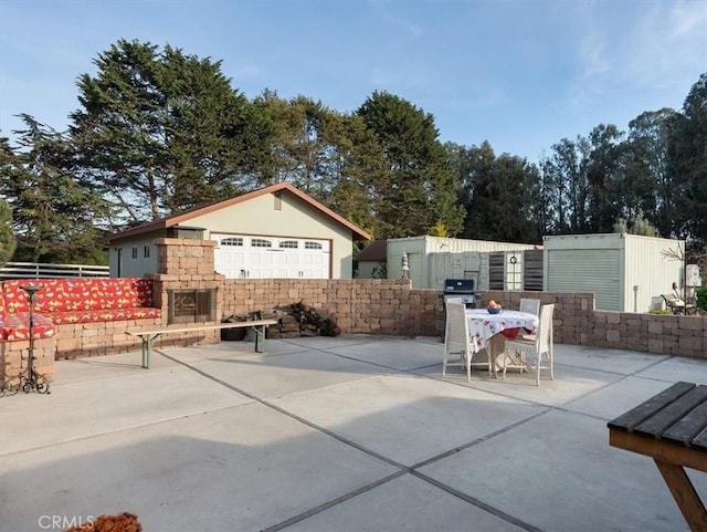 view of patio / terrace featuring grilling area, exterior fireplace, and an outdoor structure