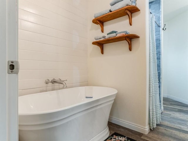 bathroom with a tub and hardwood / wood-style floors