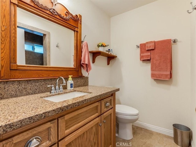 bathroom with tile patterned flooring, vanity, and toilet