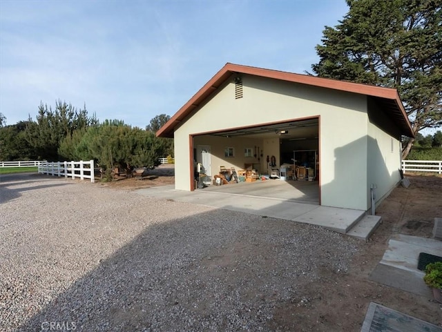 exterior space with a garage and an outbuilding