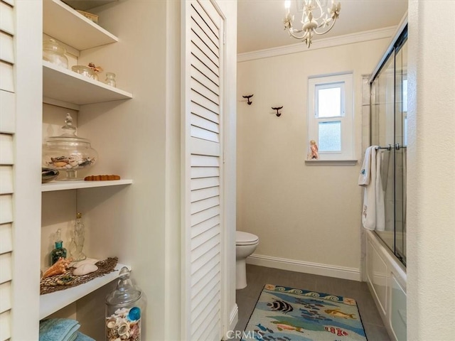 bathroom featuring tile patterned floors, ornamental molding, a notable chandelier, enclosed tub / shower combo, and toilet