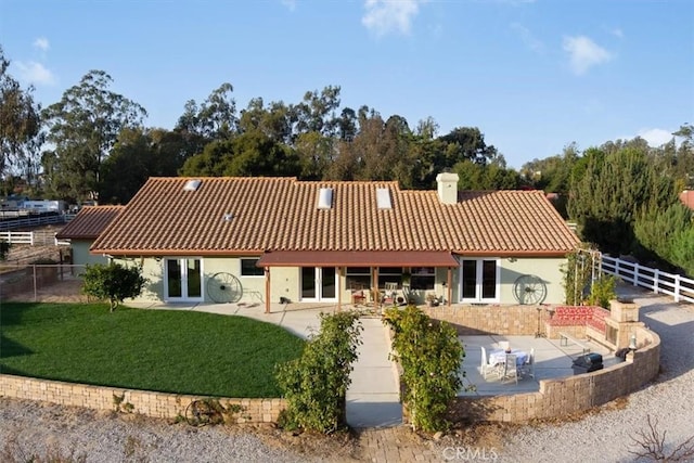 rear view of property featuring a patio area, a yard, and french doors