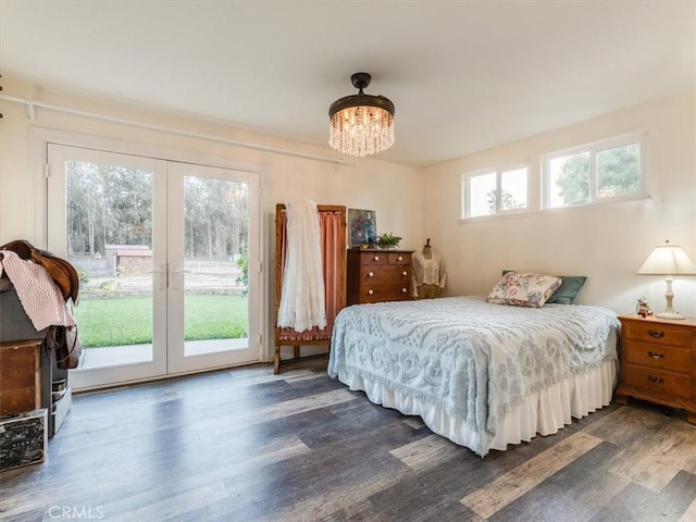 bedroom with french doors, access to outside, an inviting chandelier, and dark wood-type flooring