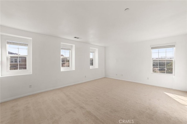 carpeted empty room featuring a wealth of natural light