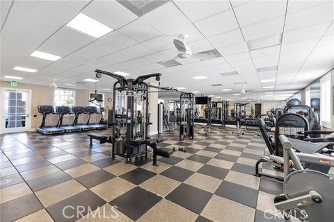 workout area with a paneled ceiling and ceiling fan